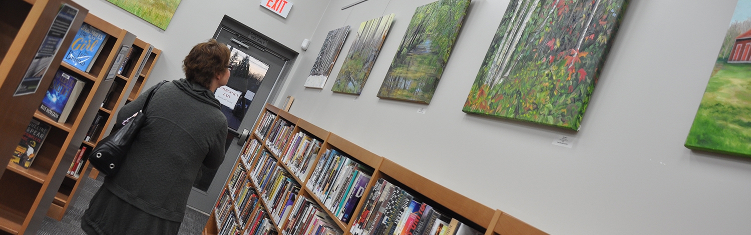 interior stacks of library with art on wall