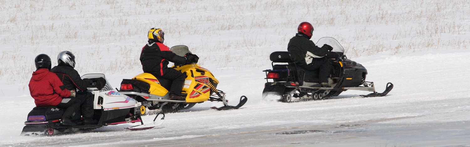 pack of snowmobilers on trail